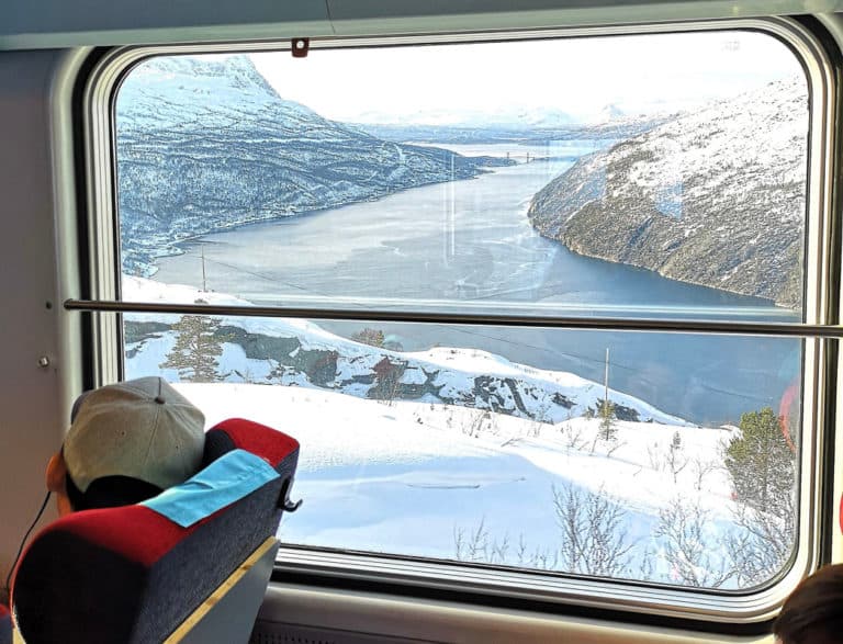 Ofoten railway running along the fjord near Narvik, steep mountains dropping into calm water