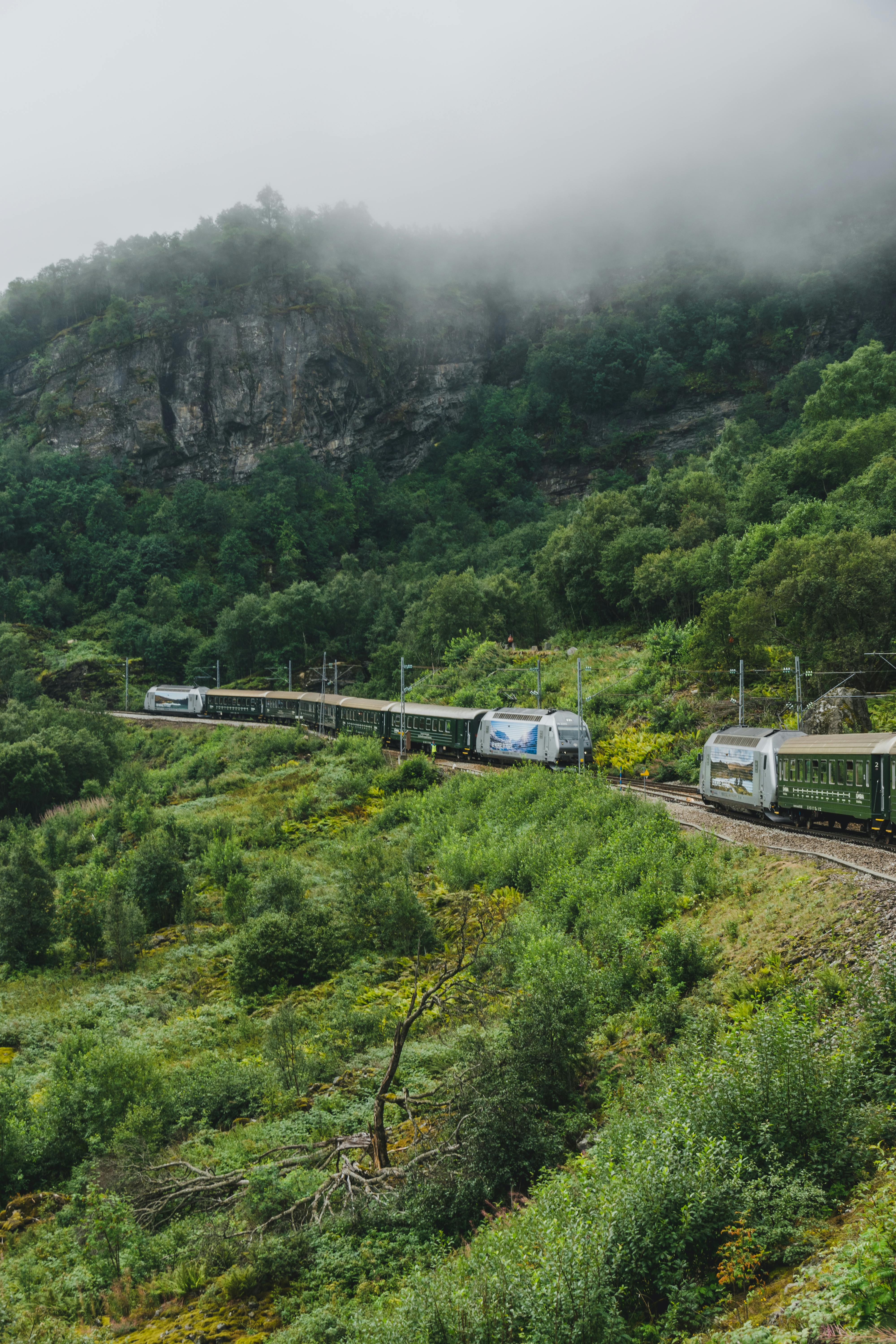 Flåm Railway train on the mountain section between Myrdal and Flåm. Snow and low cloud at altitude.