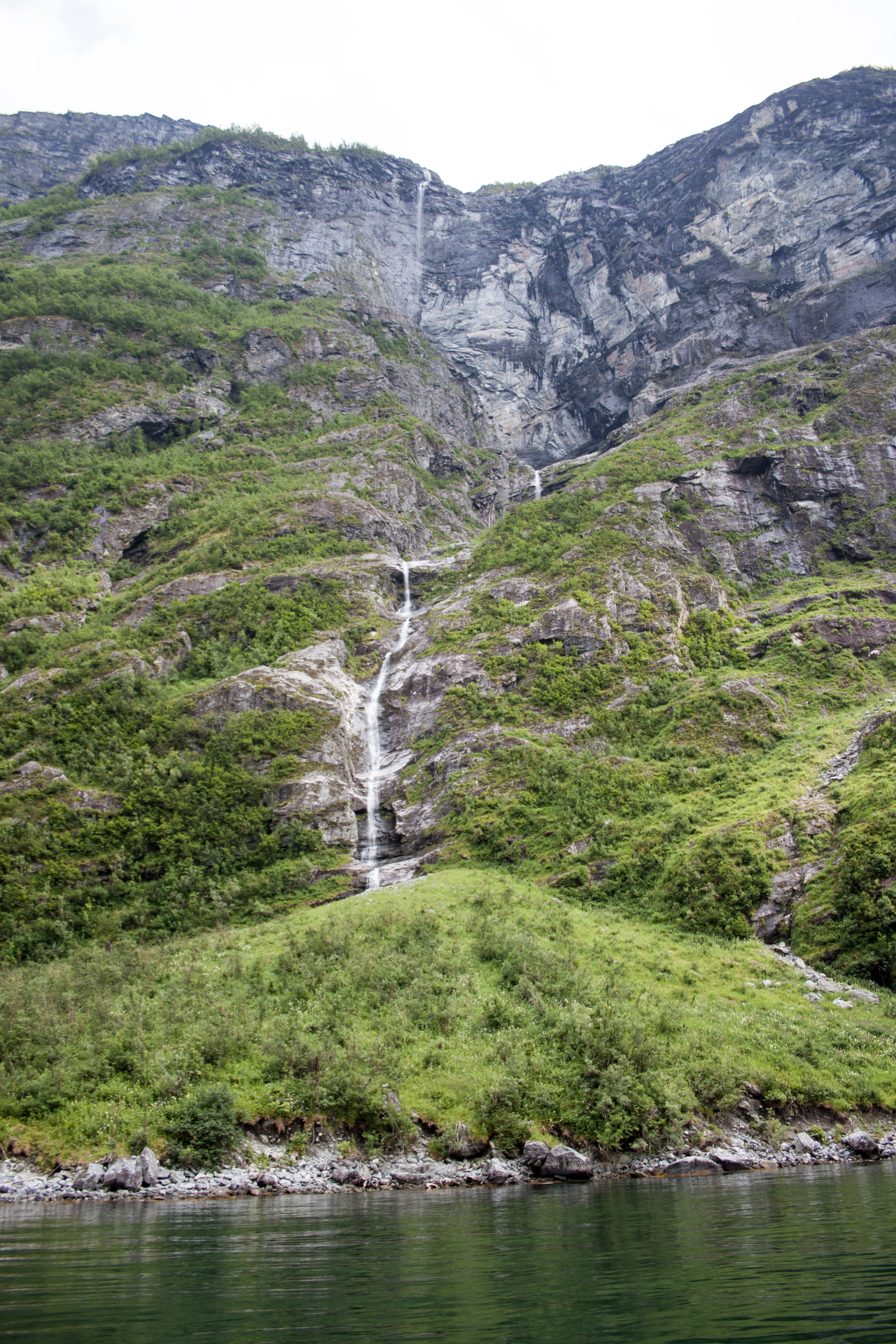 Waterfall cascading down a steep cliff face at Geirangerfjord, the route of the Fossevandring steel stair walk